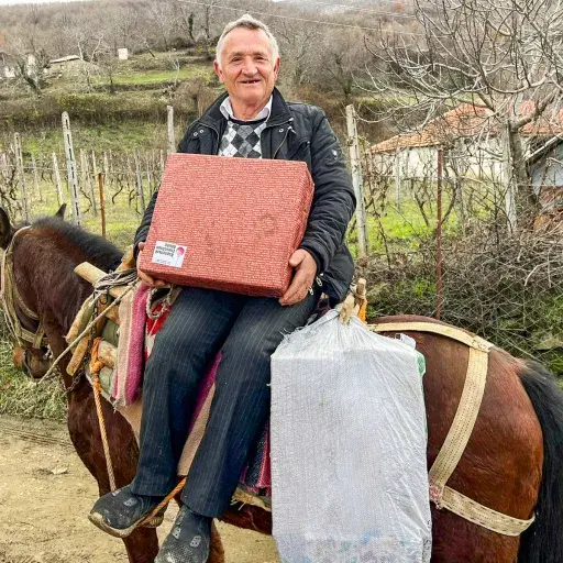 lächelnder Mann mit Päckli auf Pferd