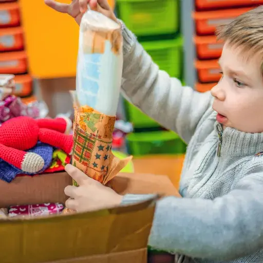 erstaunter Junge packt Päckli aus